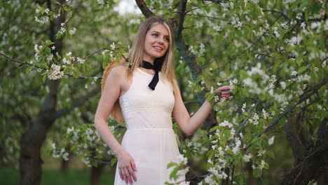 portrait-of-charming-young-woman-in-blooming-garden-attractive-lady-is-standing-under-fruit-tree